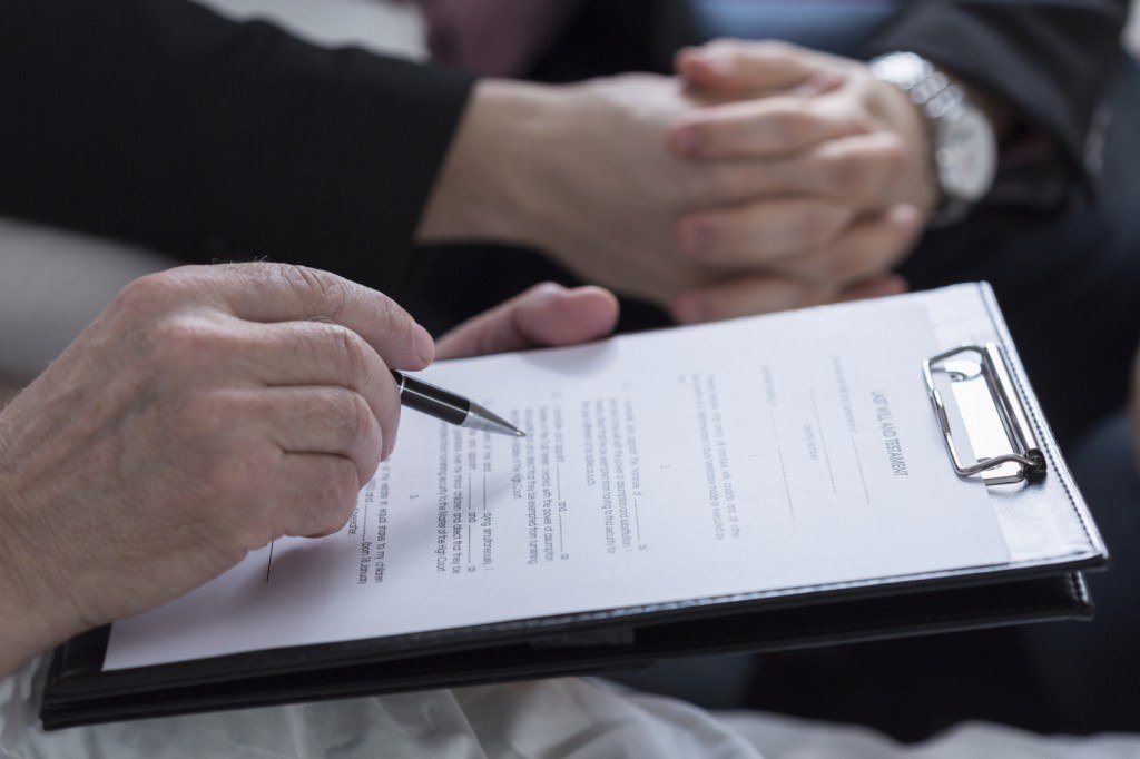 A couple holding hands and reading through a trust and probate document.