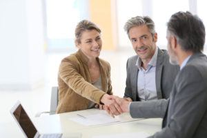 Middle aged couple meeting with lawyer about trust administration.