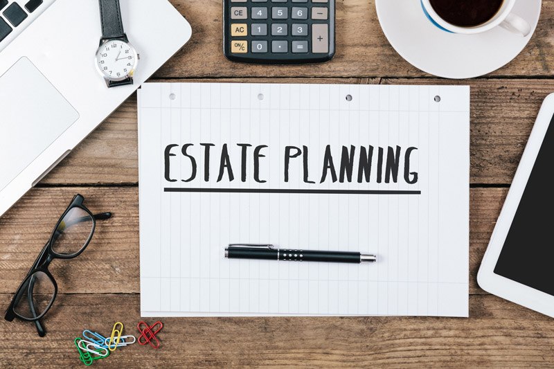 Estate planning preparation concept. Desktop with laptop, calculator, and notepad.